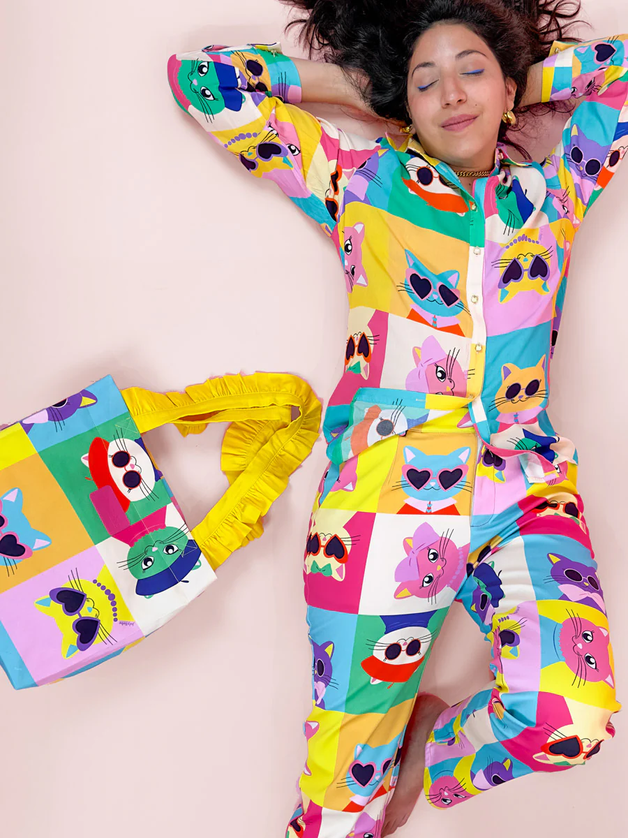 Smiling lady wearing juliebe pantsuit lying down with eyes closed and smiling